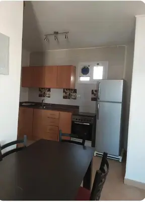 a kitchen with a black table and a refrigerator at One bedroom flat with large terrace in a villa with swimming pool in Hurghada