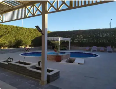 a patio with a pool and a pergola at One bedroom flat with large terrace in a villa with swimming pool in Hurghada
