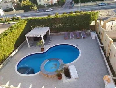 an overhead view of a swimming pool with a table and chairs at One bedroom flat with large terrace in a villa with swimming pool in Hurghada