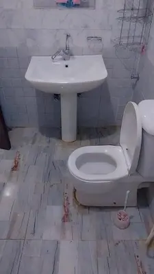 a white bathroom with a sink and a toilet at Luxor downtown in Jazīrat al ‘Awwāmīyah