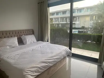 a bed in a bedroom with a large window at Hotel apartment G Cribs Hotel in Hurghada