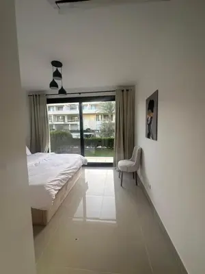 a bedroom with a bed and a chair and a window at Hotel apartment G Cribs Hotel in Hurghada