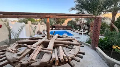 a pile of logs sitting next to a pool at Beit El-Abd Valley of Queens View in Luxor