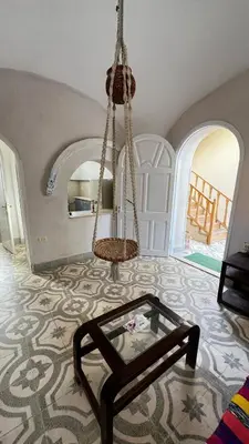 a living room with a glass table and a swing at Beit El-Abd Valley of Queens View in Luxor
