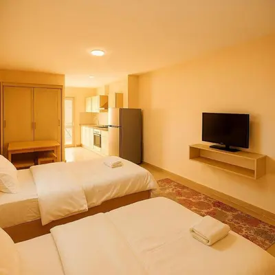 a hotel room with two beds and a flat screen tv at Golden tiba resort in Hurghada