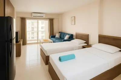 a hotel room with two beds and a blue couch at Golden tiba resort in Hurghada