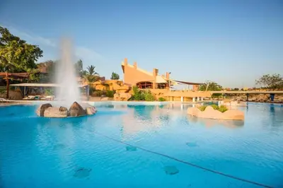 a fountain in the middle of a swimming pool at Five stars Hotel included Aswan Sightseeing and Abusimble in Nag` el-Ramla