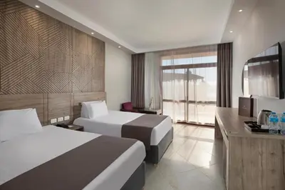 a hotel room with two beds and a television at Five stars Hotel included Aswan Sightseeing and Abusimble in Nag` el-Ramla