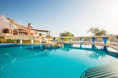 a large swimming pool with a bridge over it at Five stars Hotel included Aswan Sightseeing and Abusimble in Nag` el-Ramla