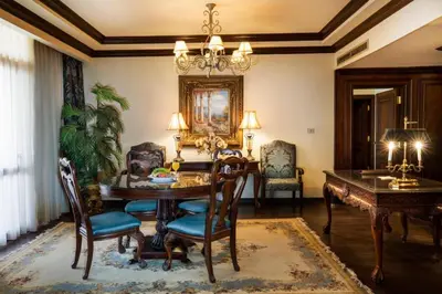 a dining room with a table and chairs and a chandelier at Five stars Hotel included Aswan Sightseeing and Abusimble in Nag` el-Ramla