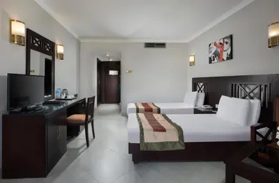 a bedroom with a bed and a desk and a television at Five stars Hotel included Aswan Sightseeing and Abusimble in Nag` el-Ramla