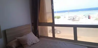 a room with a window with a view of the beach at Sea View Qussier in Quseir