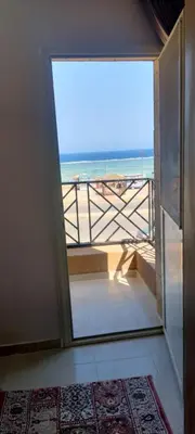 an open door to a balcony with a view of the beach at Sea View Qussier in Quseir