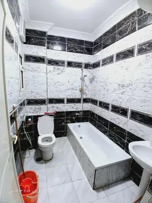 a bathroom with a tub and a toilet and a sink at Hotel apartments in Hurghada