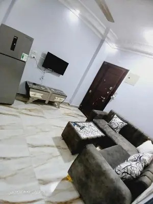 a living room with a couch and a flat screen tv at Hotel apartments in Hurghada