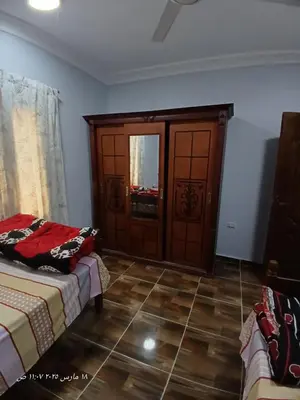 a room with two beds and a wooden door at Hotel apartments in Hurghada