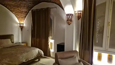a bedroom with a bed and a chair in a room at House Mountain in Luxor