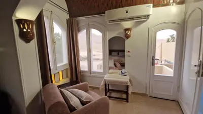 a living room with a couch and two windows at House Mountain in Luxor