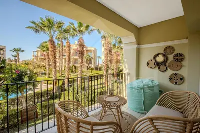 a balcony with a table and chairs and palm trees at Ladybird - Veranda Celestia in Hurghada