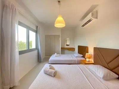 two beds in a white room with a window at Hotel apartment swan lake in Hurghada