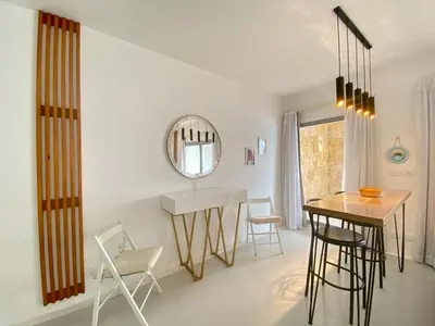 a dining room with a table and chairs and a mirror at Hotel apartment swan lake in Hurghada