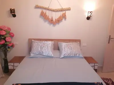 a bed with two pillows and a cross on the wall at الكوثر القديم الغردقة in Hurghada