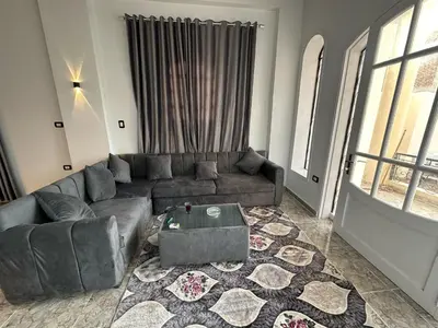 a living room with a couch and a table at Nsma house in Al Aqālitah