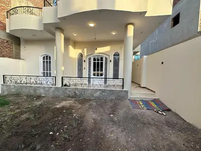a large white house with a driveway in front of it at Nsma house in Al Aqālitah