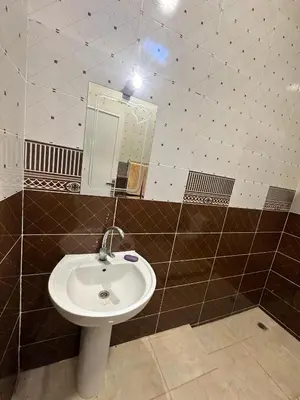 a bathroom with a sink and a mirror at Nsma house in Al Aqālitah