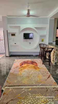 a living room with a table and a tv on a wall at sky spirit in Luxor