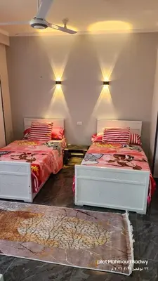 two beds in a bedroom with red and white sheets at sky spirit in Luxor