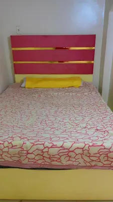 a bedroom with a bed with a red head board at habby home in Aswan