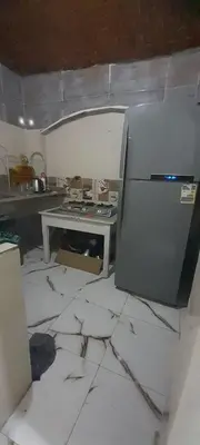 a kitchen with a refrigerator and a table in it at habby home in Aswan