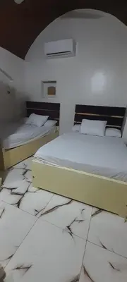 two beds in a room with a tiled floor at habby home in Aswan
