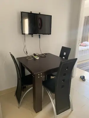 a black table with chairs and a tv on a wall at Apartment in centre of Hurghada in Hurghada
