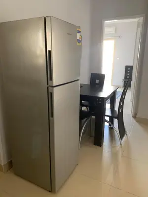 a stainless steel refrigerator in a room with a table at Apartment in centre of Hurghada in Hurghada