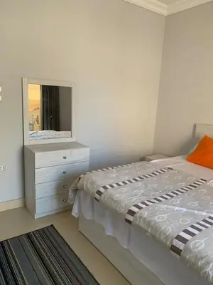 a bedroom with a bed and a dresser with a mirror at Apartment in centre of Hurghada in Hurghada