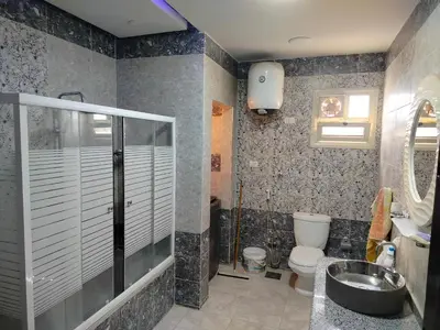 a bathroom with a shower and a toilet and a sink at اسوان ـ خلف مول بلازا ـ بجوار فرست مول in Aswān