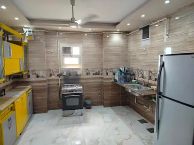 a kitchen with a stove and a refrigerator at اسوان ـ خلف مول بلازا ـ بجوار فرست مول in Aswān