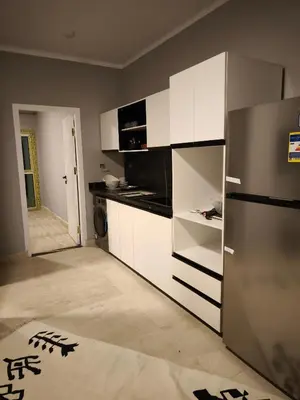 a kitchen with white cabinets and a stainless steel refrigerator at Soho compound in Hurghada
