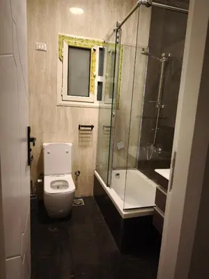 a bathroom with a toilet and a glass shower at Soho compound in Hurghada