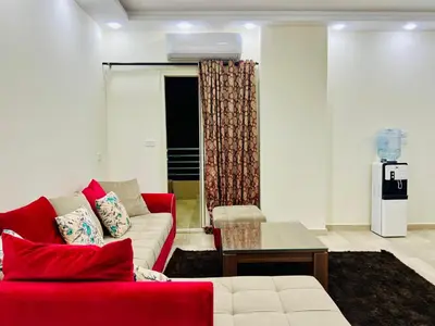 a living room with a red couch and a table at Beachfront Bliss - Your Hurghada Escape Awaits in Hurghada