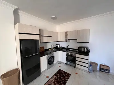 a kitchen with a black refrigerator and a dishwasher at Apartment with a Red Sea view in Hurghada