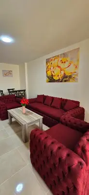 a living room with red couches and a coffee table at Tiba Golden Marina Bay Hurghada in Hurghada