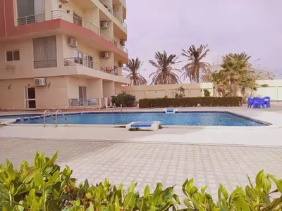 a swimming pool in front of a building at Oceanfront Apartment with Sea View - Hurghada - 2 bedrooms 2 bathrooms in Hurghada