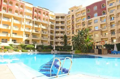 a swimming pool in front of a large building at Florenza Khamsin Resort in Hurghada