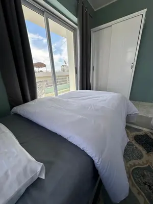 a bed in a room with a large window at Nile Spirit Sunrise in Luxor