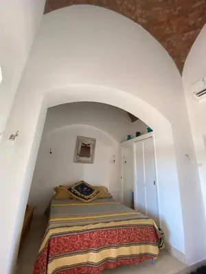 a bedroom with a bed in a white room at Apartment at Upper Nubia lagoon El Gouna in Hurghada