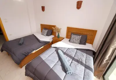 a bedroom with two beds and a window at Serenity House Luxor in Luxor