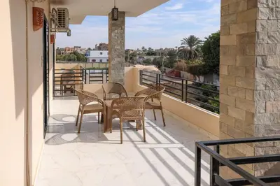 a patio with chairs and a table on a balcony at Serenity House Luxor in Luxor